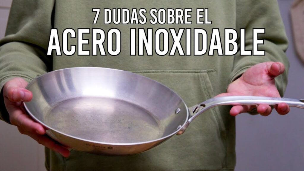 Sartén de acero inoxidable sostenida por una persona con sudadera verde
