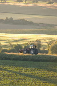 Tractor trabajando en campos verdes como ejemplo de agricultura tecnologica