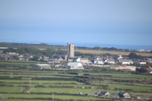 Panorámica de campos y pueblo costero que contrasta con la agricultura urbana