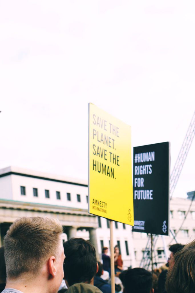 Manifestación con pancartas que piden salvar el planeta y derechos humanos, cambio climatico urgente actuar ahora.