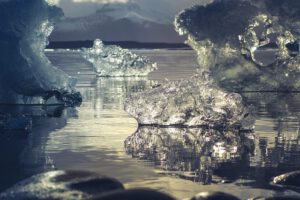 Fragmentos de hielo flotando en agua calma, reflejando un catastrofico futuro glaciares peligro extincion.