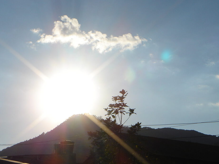 Amanecer brillante sobre una montaña con árbol en primer plano y cielo despejado clima 3.