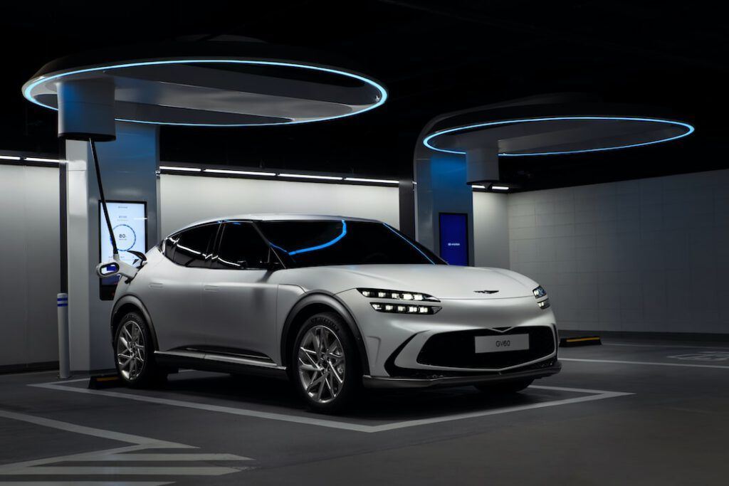 Vehículo eléctrico cargando en estación interior futurista, consejos mantener vehiculo electrico hibrido nuevo para preservar la batería.