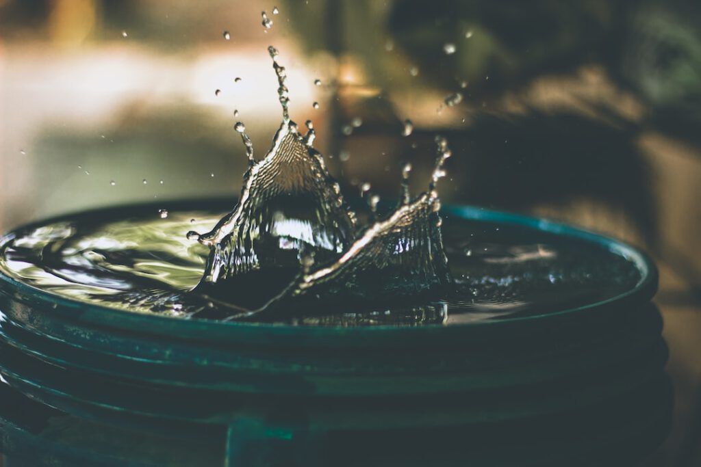 Salpicadura de agua en un recipiente que ilustra contaminacion agua salud relacionada