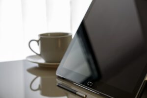 Tableta con lápiz digital junto a una taza que invita a controla consumo agua casa seguimiento eficaz