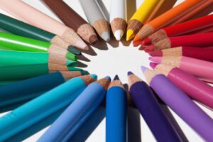 Lápices de colores afilados dispuestos en círculo sobre fondo blanco, creatividad 2 para inspiración visual