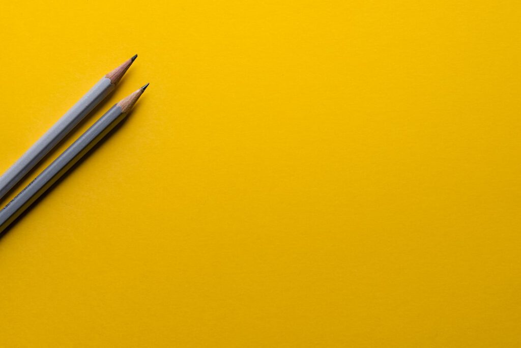 Dos lápices grises sobre fondo amarillo evoca análisis y reflexión sobre desventajas energia hidroelectrica impactos negativos