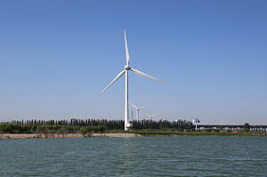 Aerogenerador junto a un cuerpo de agua evocando hidroelectrica sostenible