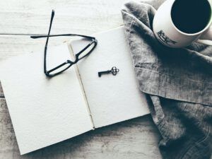 Libreta abierta con gafas, llave antigua y taza que inspira iniciativas conservar ecosistemas clave descubre