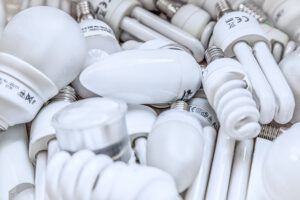 Varias bombillas y tubos compactos apilados que ilustran iniciativas reciclaje vidrio mundo mejores.