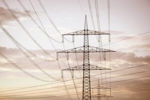 Torres y cables eléctricos al atardecer que recuerdan precauciones agua lluvia almacenada riesgos innecesarios en entornos con infraestructura eléctrica.