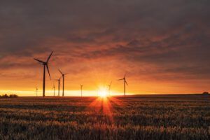 Parque eólico al amanecer que ilustra proyectos energias renovables exitosos red electrica mundial en un paisaje agrícola.