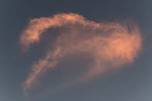 Nube anaranjada en forma de signo de interrogación sobre cielo azul grisáceo, radiacion segura 1