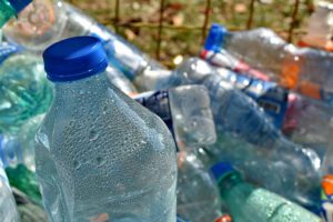 Botellas de plástico PET con gotas y tapones azules apiladas para reciclaje 3