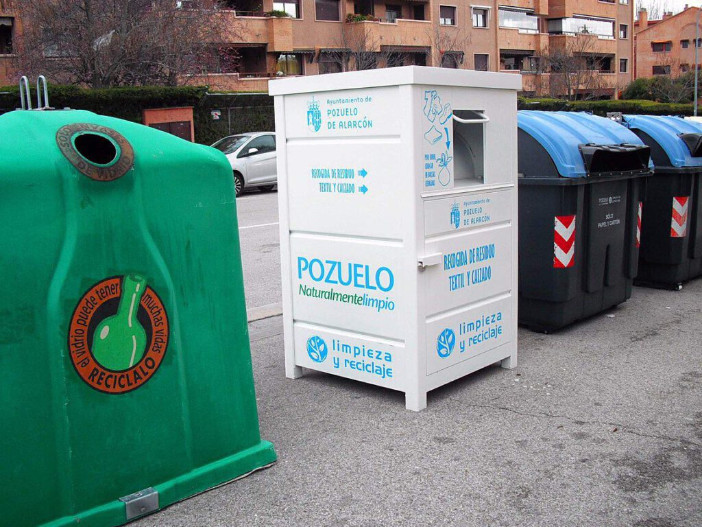 Filas de contenedores de reciclaje 5 con un módulo blanco de recogida textil y un contenedor verde para vidrio