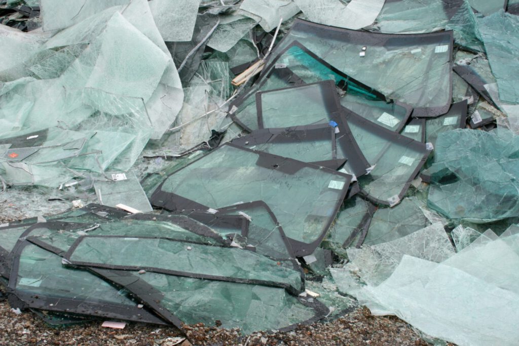 Parabrisas y cristales rotos en pila con bordes verdosos reciclaje de plasticos 1