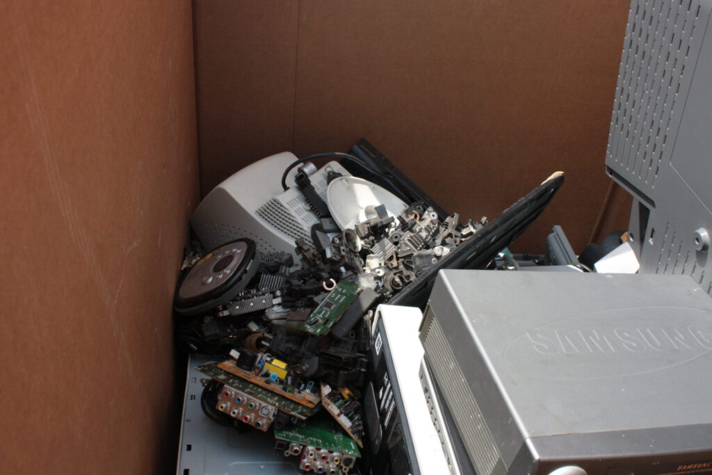 Caja con aparatos y placas desmontadas preparadas para reciclaje tecnologico.