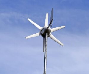 Aerogenerador compacto montado en mástil contra cielo azul que sugiere tecnologia limpiar aire