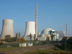 Planta de energía con torres de enfriamiento y edificio en cúpula, ilustrando termica sostenible.