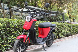 Scooter eléctrico rojo estacionado en una acera que representa transporte sostenible 1