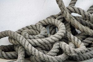 Cuerdas marítimas gruesas y enredadas que evocan cooperación, uniendo fuerzas aumento nivel mar acidificacion oceanica solucion paises trabajando juntos.