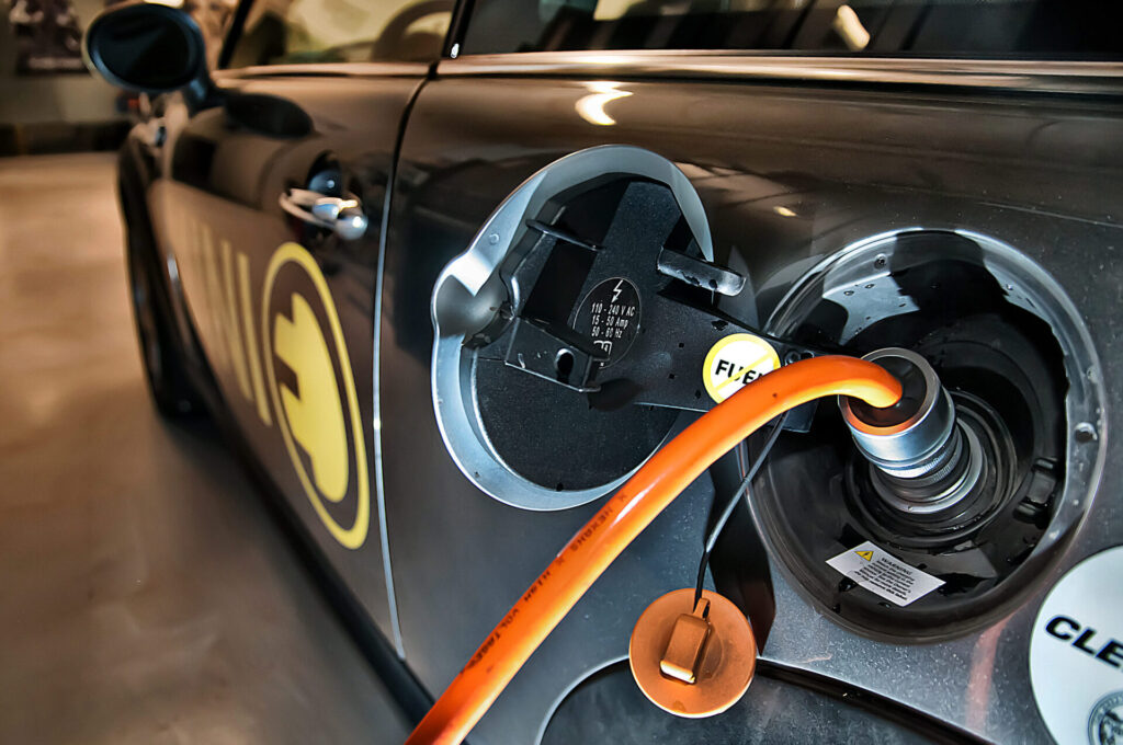 Puerto de carga de coche eléctrico con cable naranja conectado, vehiculos electricos 1.